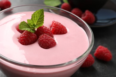 Photo of Delicious raspberry mousse with mint in glass dish, closeup