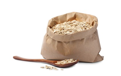 Photo of Raw oatmeal, paper bag and wooden spoon on white background