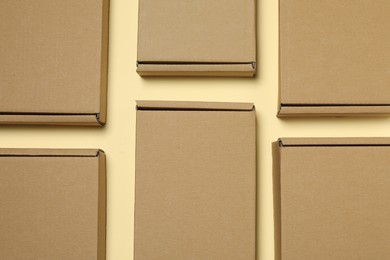 Many closed cardboard boxes on pale yellow background, flat lay