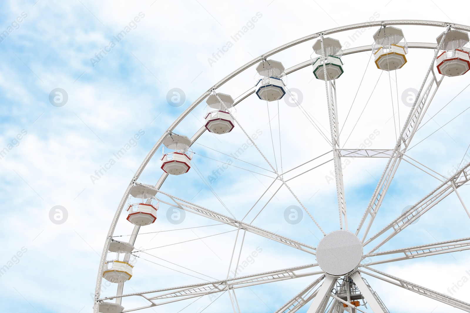 Photo of Large white observation wheel with cabins against sky