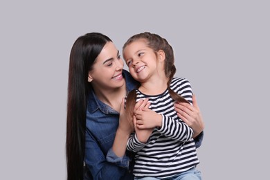 Photo of Happy woman with her cute daughter on light grey background. Mother's day celebration