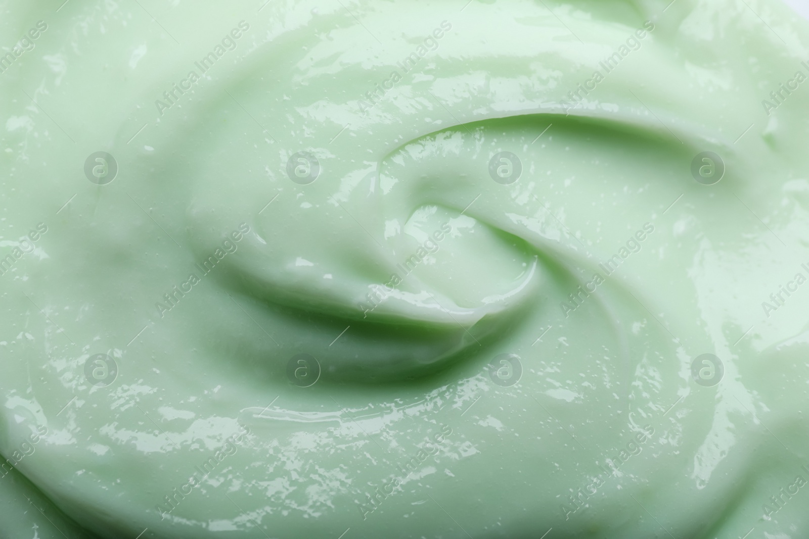 Photo of Closeup view of light green body cream as background