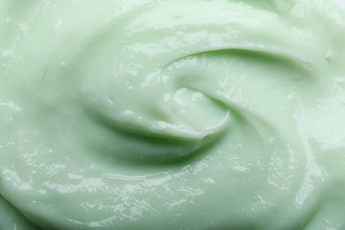 Closeup view of light green body cream as background
