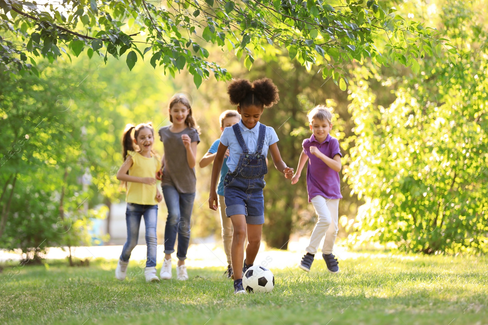 Photo of Cute little children playing with ball outdoors on sunny day