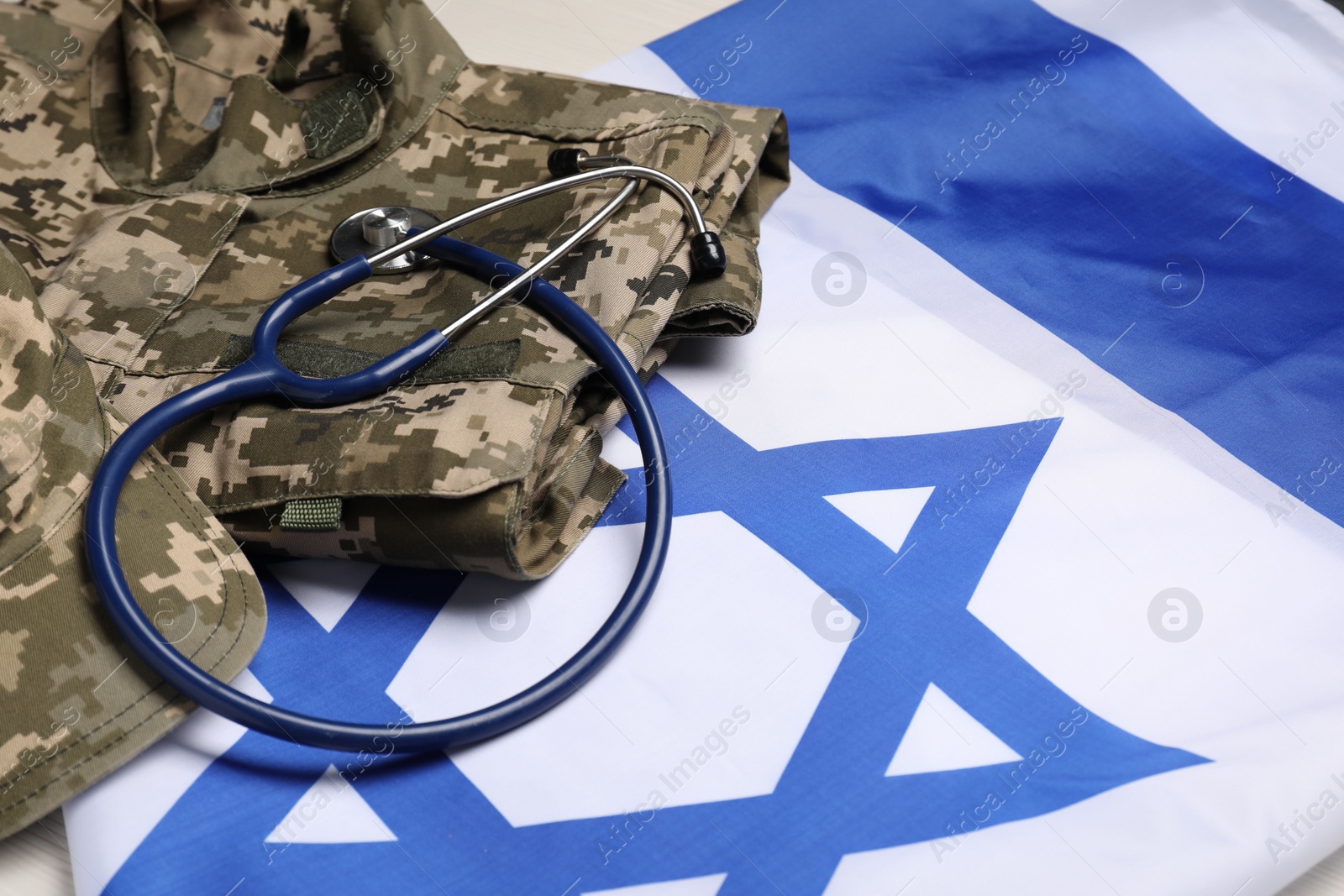 Photo of Stethoscope and military uniform on flag of Israel, closeup