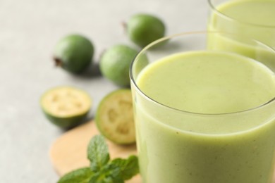 Photo of Fresh feijoa smoothie in glass on table, closeup view