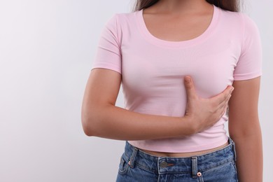 Woman doing breast self-examination on white background, closeup. Space for text