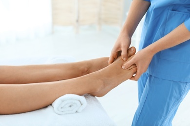 Photo of Woman receiving leg massage in wellness center, closeup