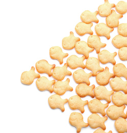 Photo of Delicious crispy goldfish crackers on white background, top view