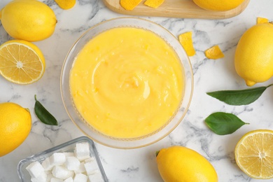 Delicious lemon curd and fresh fruits on white marble table, flat lay