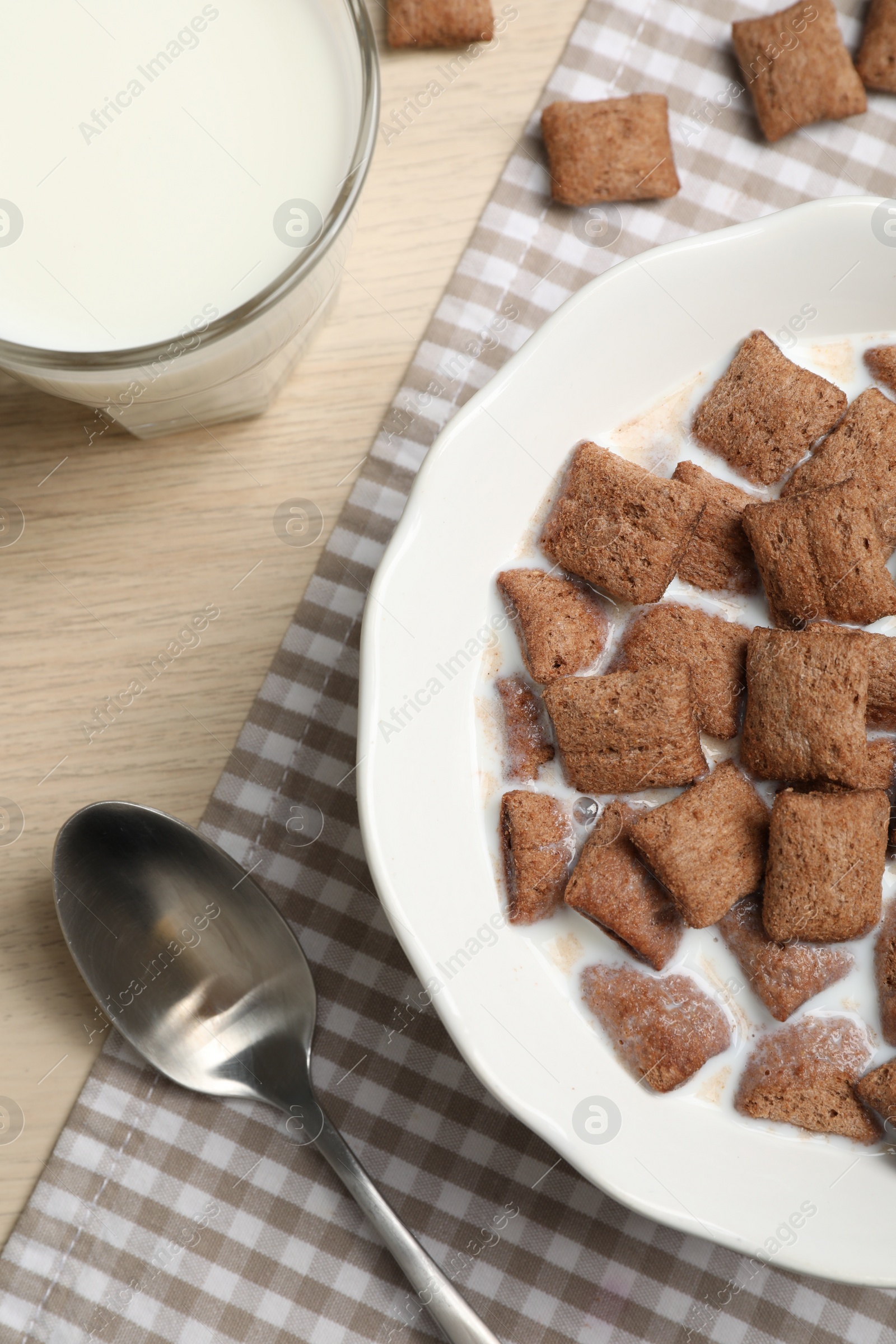 Photo of Bowl with tasty corn pads and milk on wooden table, flat lay