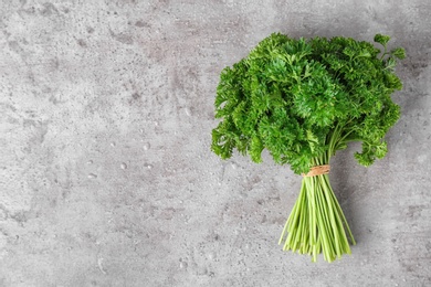 Photo of Fresh green parsley and space for text on grey background, top view