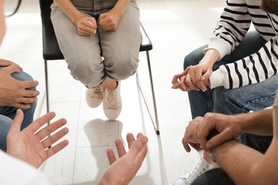 Psychotherapist working with group of drug addicted people at therapy session, closeup