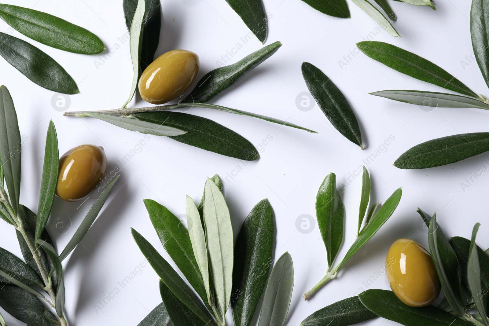 Photo of Fresh green olives and leaves on white background, flat lay