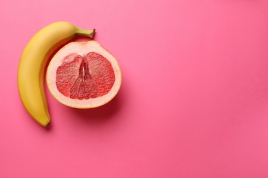 Photo of Banana and half of grapefruit on pink background, flat lay with space for text. Sex concept
