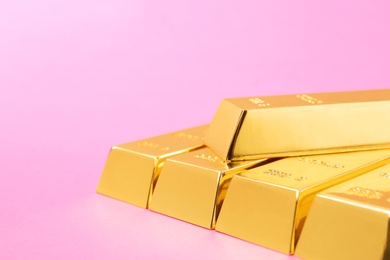 Precious shiny gold bars on color background. Space for text