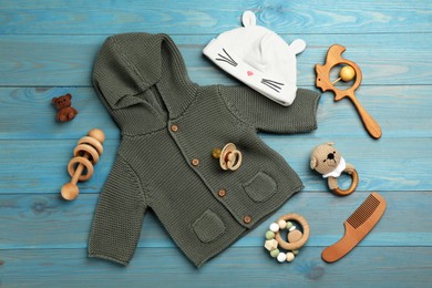Photo of Flat lay composition with baby clothes and accessories on light blue wooden table