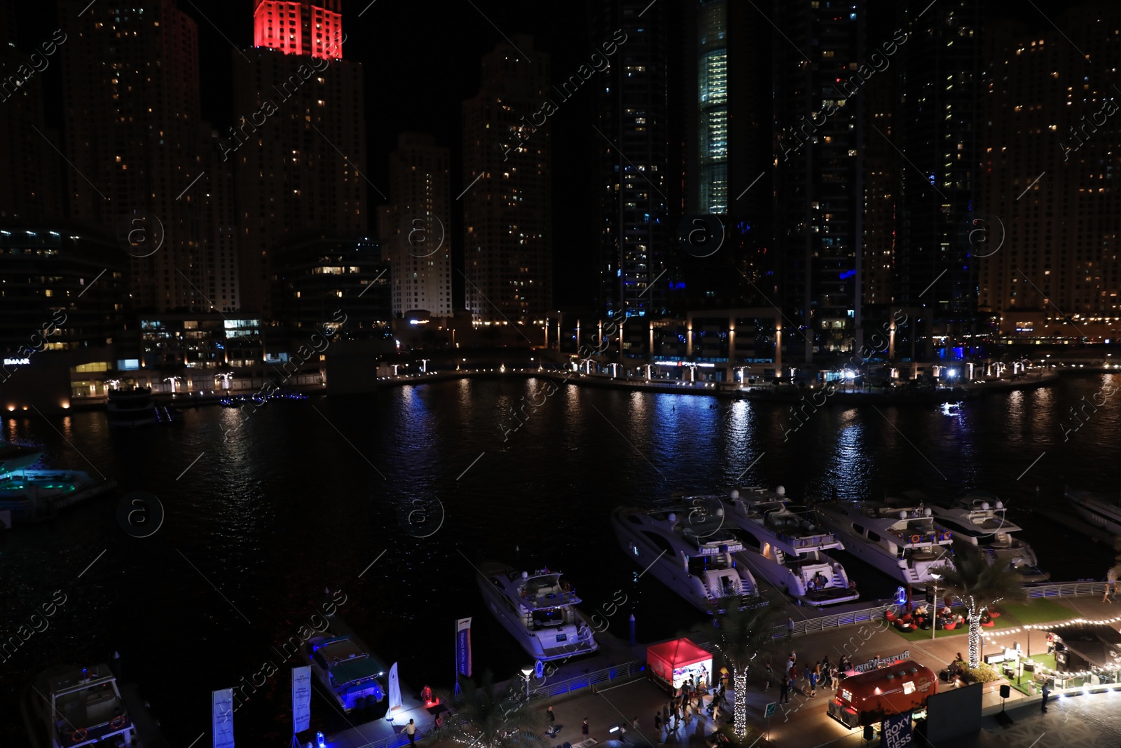 Photo of DUBAI, UNITED ARAB EMIRATES - NOVEMBER 03, 2018: Night cityscape of marina district with moored yachts