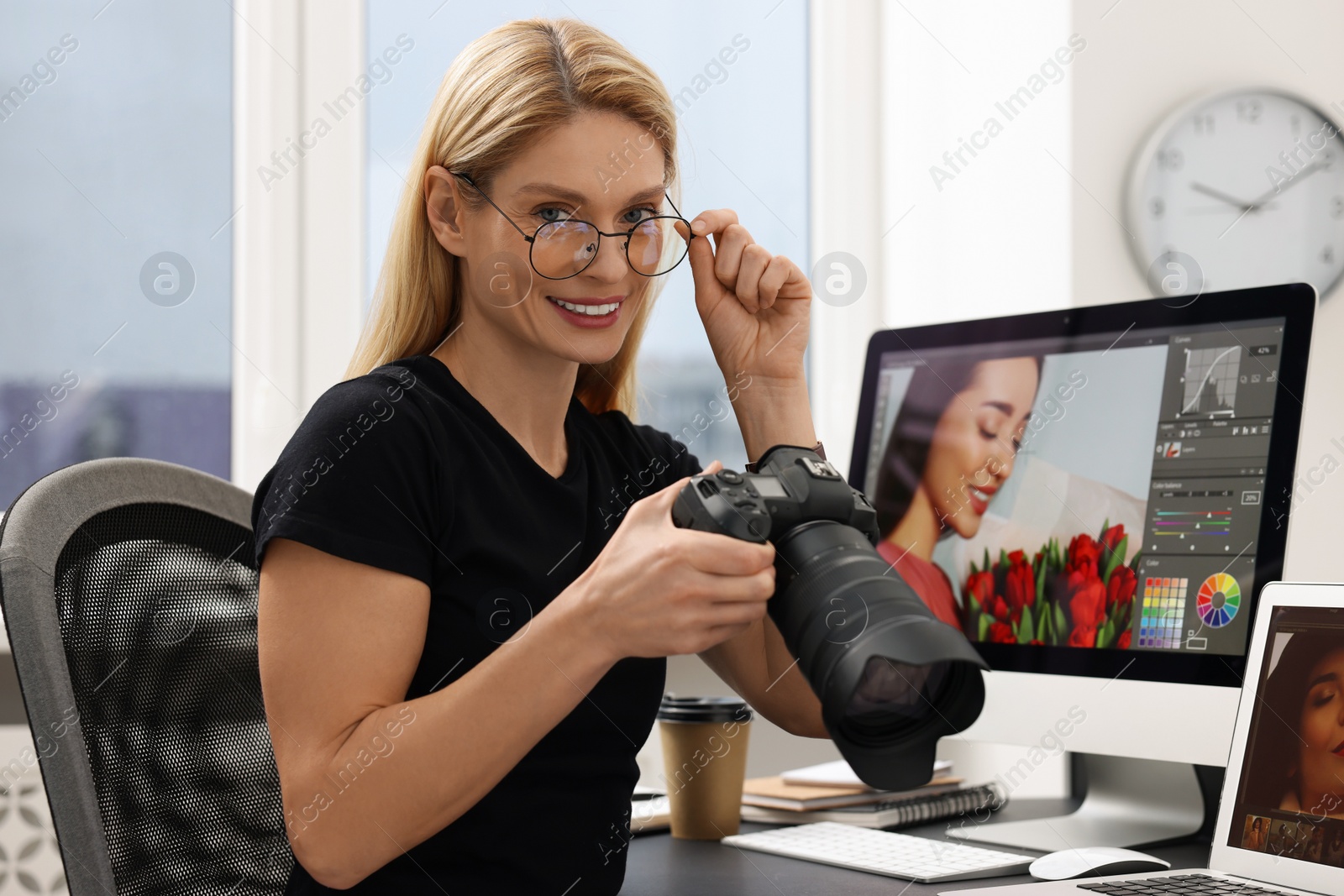 Photo of Professional photographer with digital camera at table in office