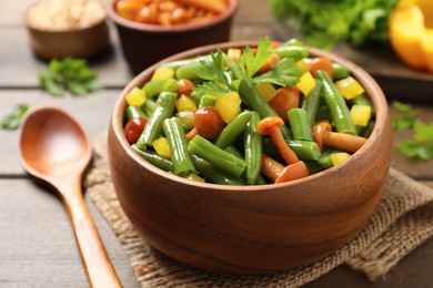 Photo of Tasty salad with green beans served on wooden table, closeup