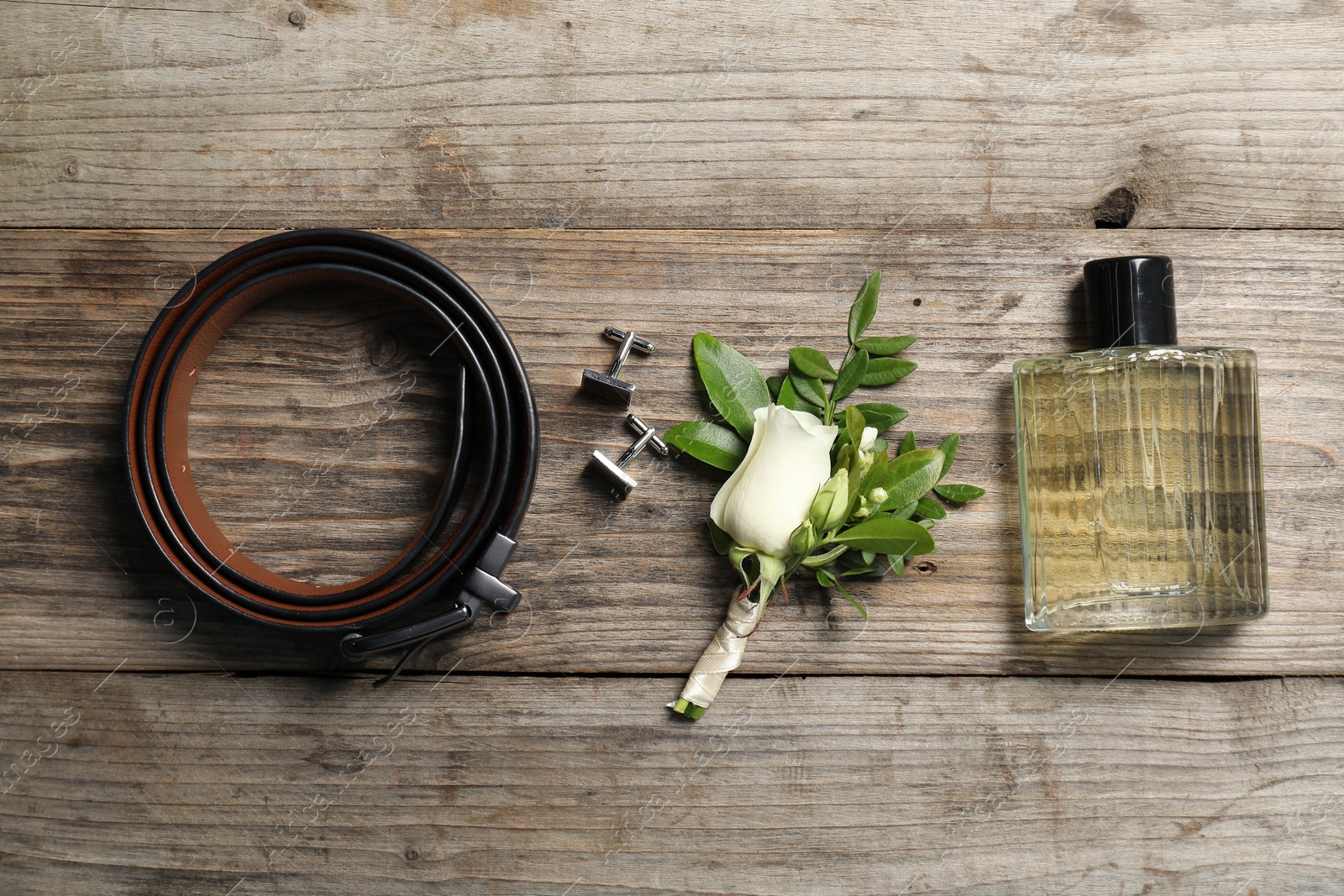 Photo of Wedding stuff. Flat lay composition with stylish boutonniere on wooden table