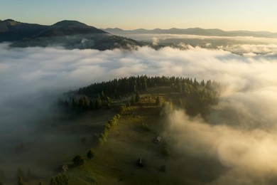 Image of Aerial view of beautiful landscape with misty forest in mountains