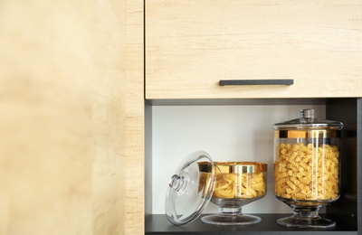 Photo of Products in modern kitchen glass containers on shelf