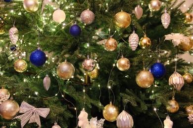 Photo of Beautifully decorated Christmas tree with different baubles, closeup