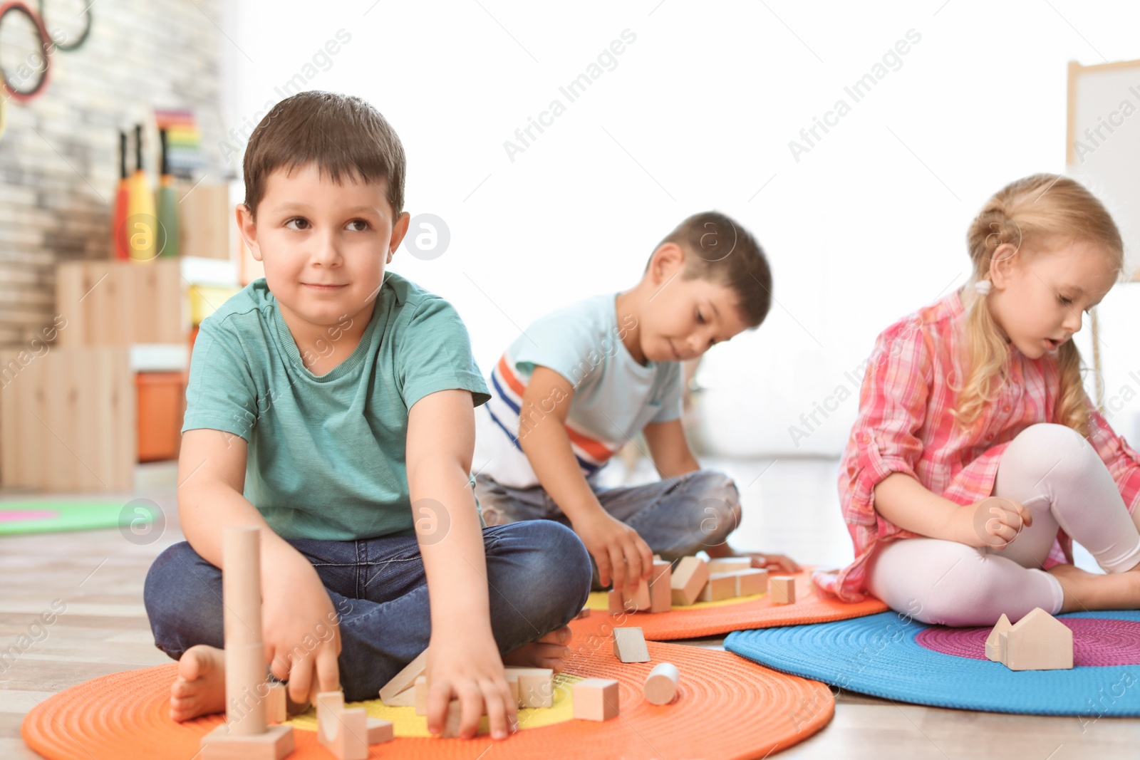 Photo of Cute little children playing with wooden blocks indoors