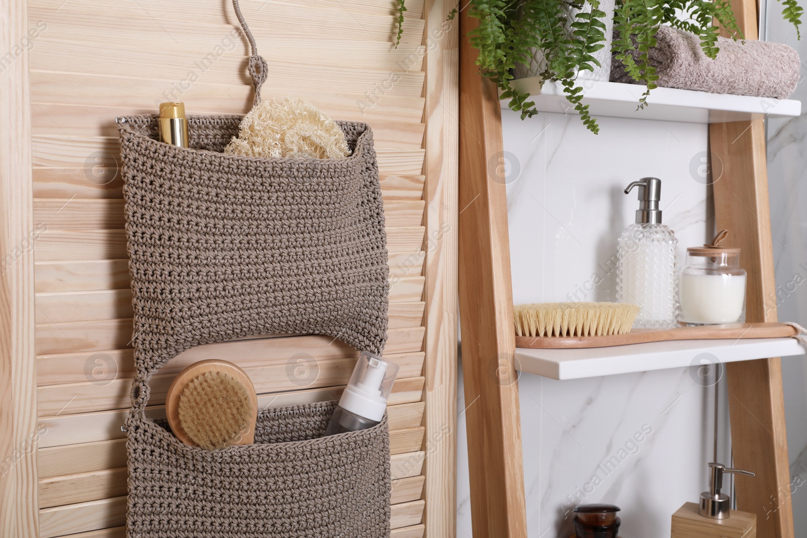 Photo of Shelving unit and organizer with essentials in bathroom. Stylish accessory