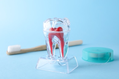 Photo of Tooth model, floss and brush on color background, space for text. Dentist consultation