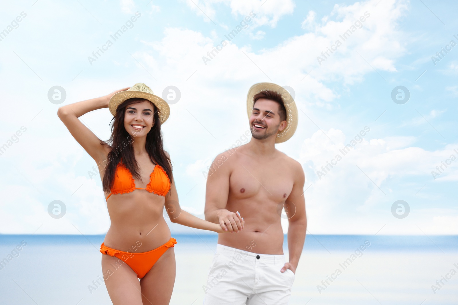 Photo of Happy young couple walking together on beach