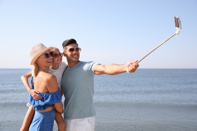 Photo of Happy family taking selfie at beach on sunny day