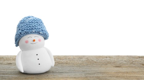 Photo of Cute decorative snowman in blue hat on wooden table against white background, space for text