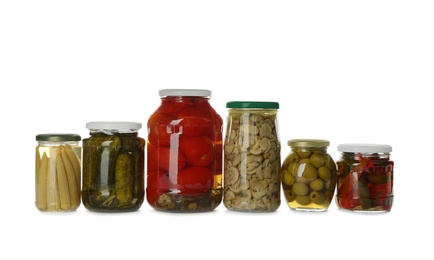 Photo of Glass jars with different pickled vegetables and mushrooms on white background