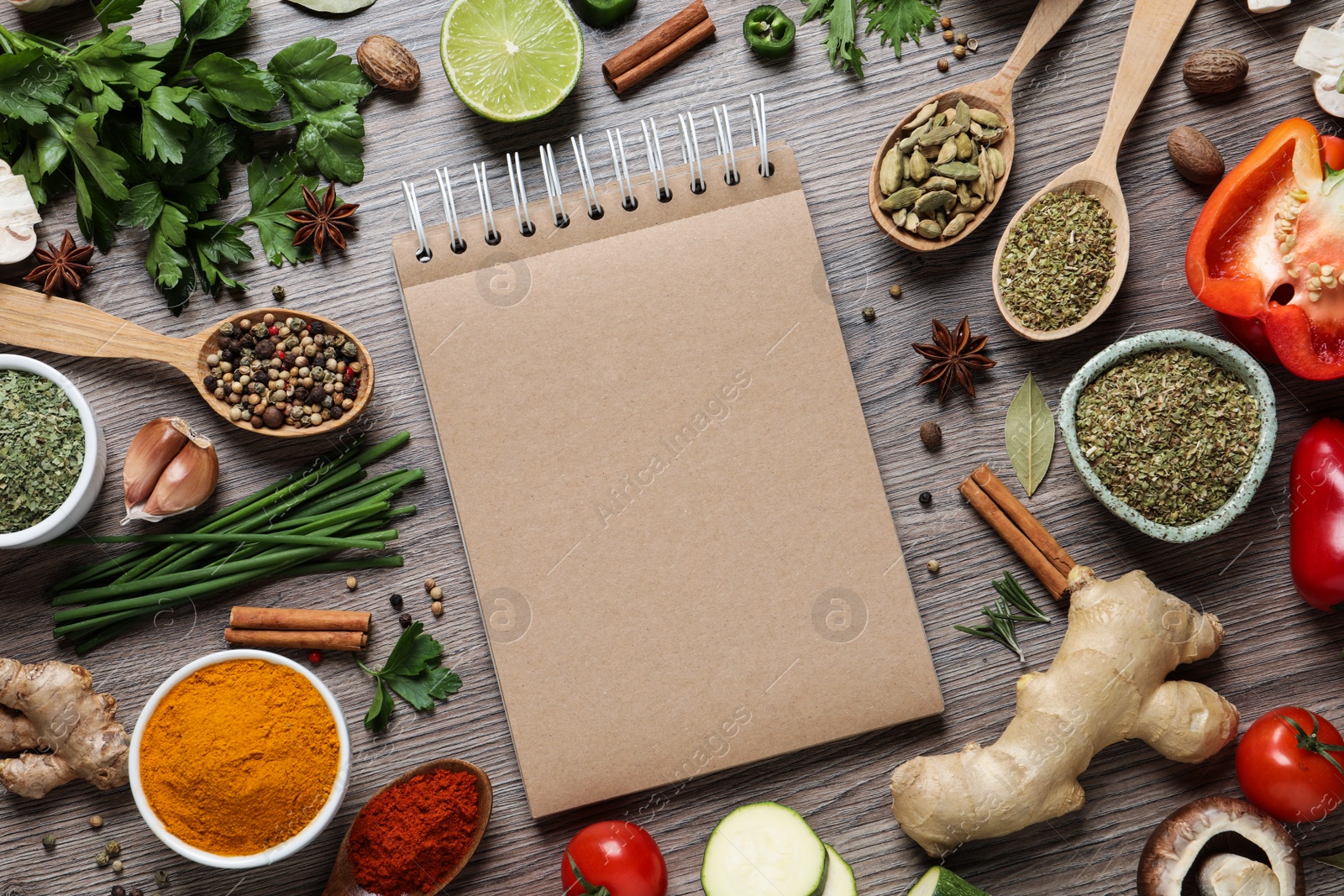 Photo of Open recipe book and different ingredients on wooden table, flat lay. Space for text