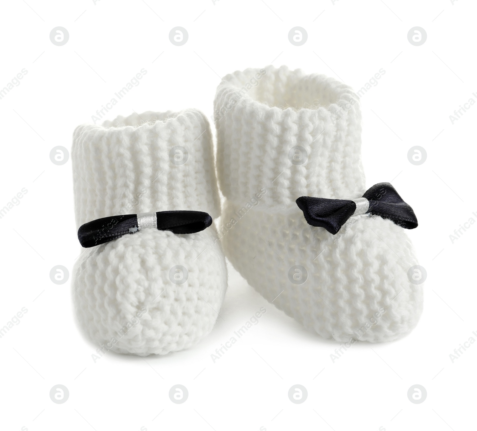 Photo of Handmade baby booties with bows isolated on white