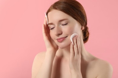 Photo of Beautiful woman with freckles wiping face on pink background