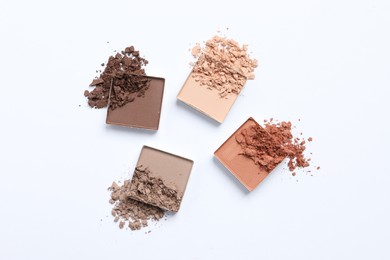 Photo of Crushed eye shadows on white background, top view. Professional makeup product