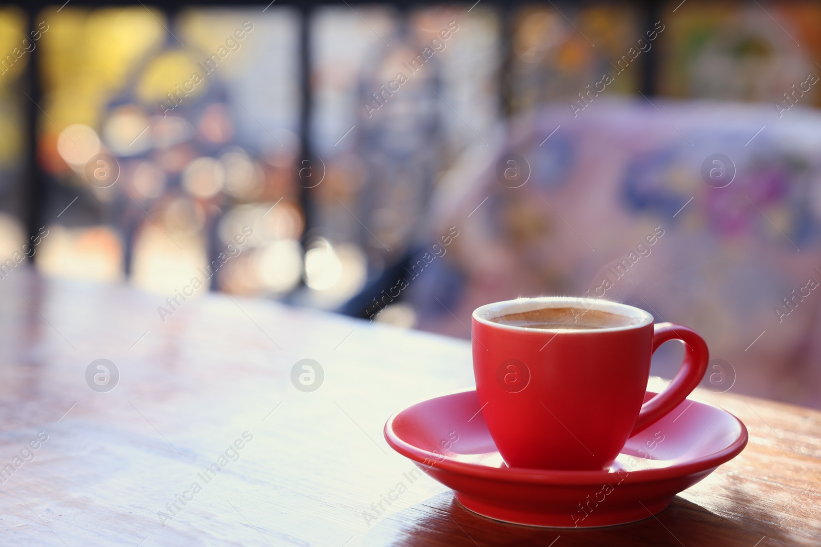 Photo of Cup of hot aromatic coffee on table in outdoor cafe. Space for text