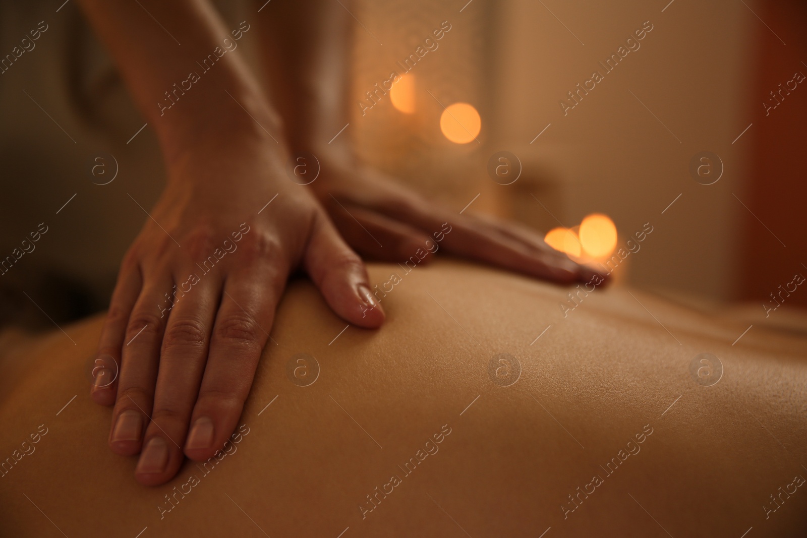 Photo of Young woman receiving back massage in spa salon, closeup