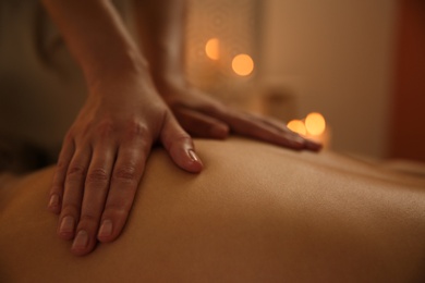 Young woman receiving back massage in spa salon, closeup