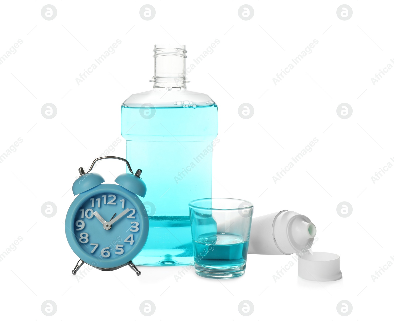 Photo of Mouthwash, paste and alarm clock on white background