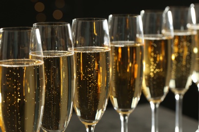 Photo of Many glasses of champagne on blurred background, closeup