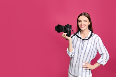 Photo of Professional photographer with modern camera on pink background. Space for text