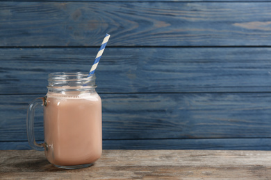 Protein shake on wooden table, space for text