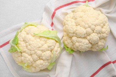 Photo of Whole fresh raw cauliflowers on white table, flat lay