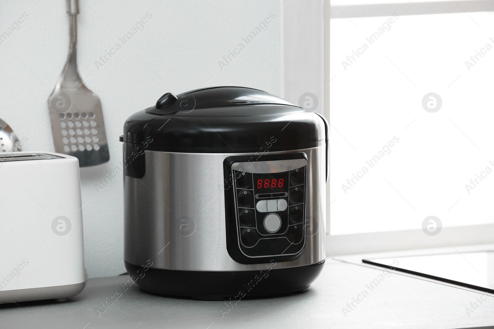 Photo of Modern electric multi cooker on kitchen countertop