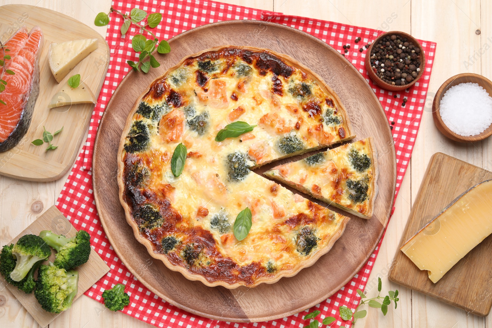 Photo of Delicious homemade quiche and ingredients on table, flat lay