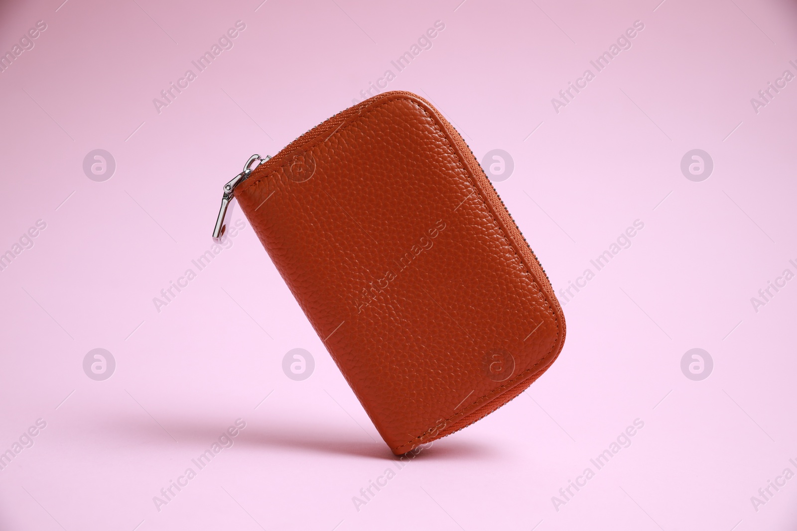 Photo of Stylish brown leather purse on pink background